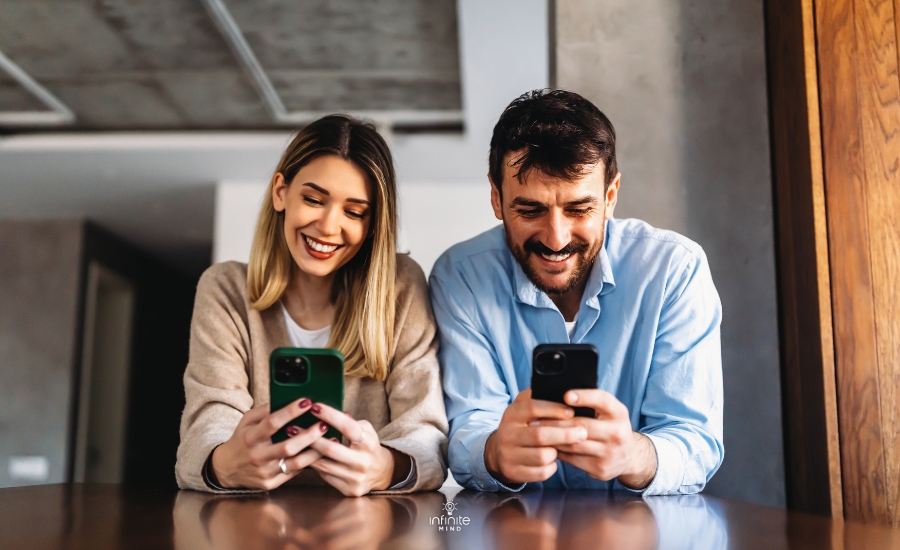 smiling-couple-embracing-while-looking-at-smartphone