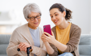 A woman showing another elderly woman a phone