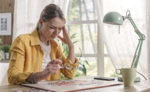 Woman solving a puzzle and having a headache