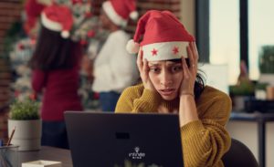 Holiday stressed and tired woman trying to work in noisy office