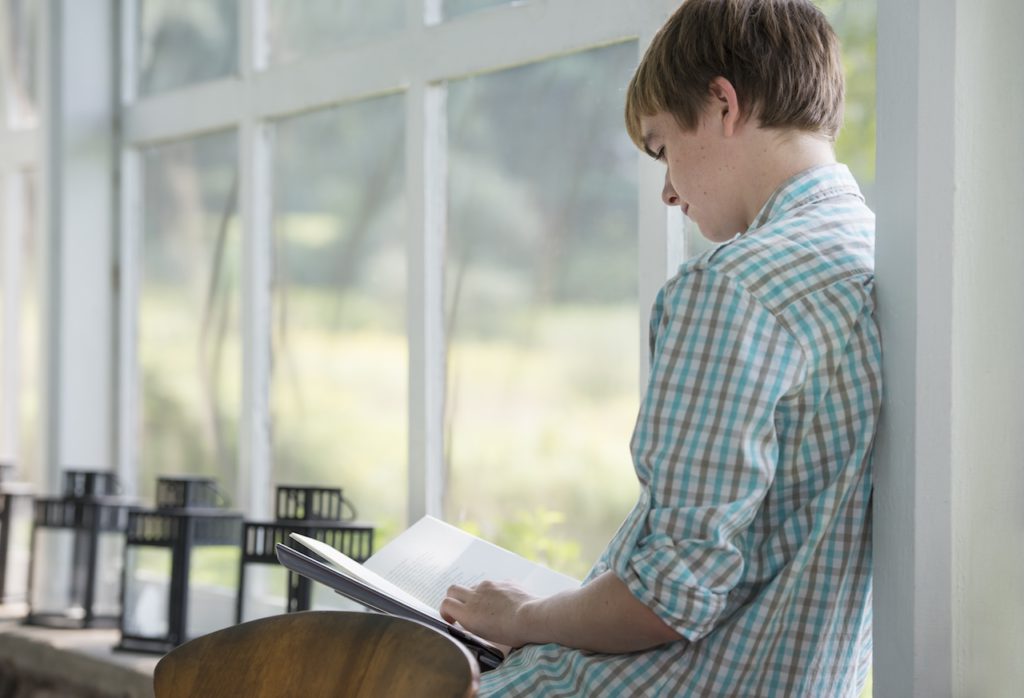 teenager reading book for school