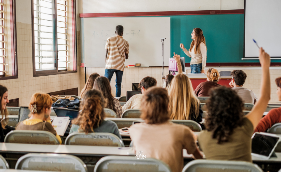 A student at the blackboard giving answers before the eyes of his teacher and classmates