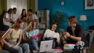A view of students collaborating and practicing reading skills with digital devices and notebooks in a cozy study space.