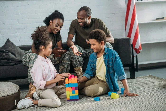 A view of a family sitting together on the floor building colorful blocks, illustrating connection, engagement, and play. 