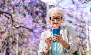 Woman in her 60s using her phone smiling