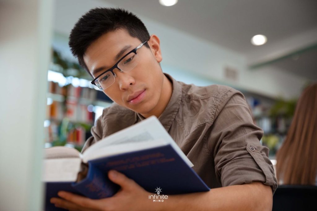 university student reading book in library