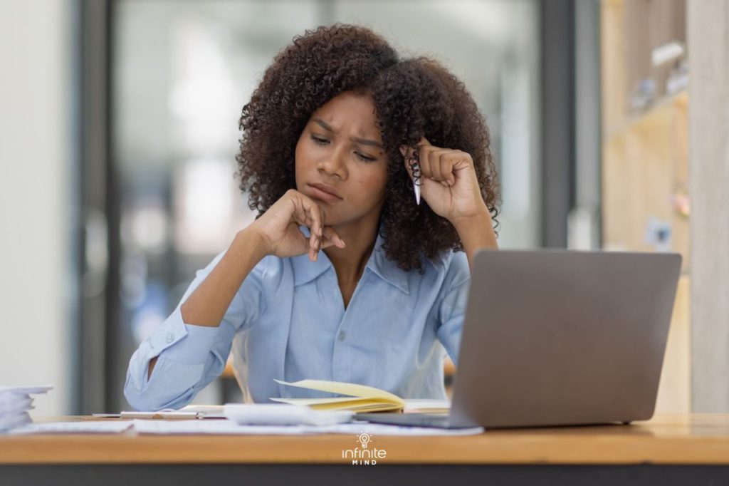 young woman working on a computer trying to figure out a complex problem