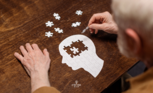 high angle view of senior man collecting jigsaw puzzle as dementia rehab