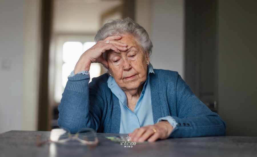 Senior Woman Looks Concerned at Table Indoors