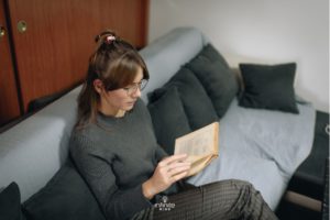 woman reading a book at home while focusing on new information
