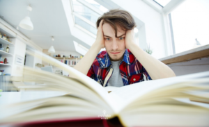 Stressed Man with Head in Hands Studying