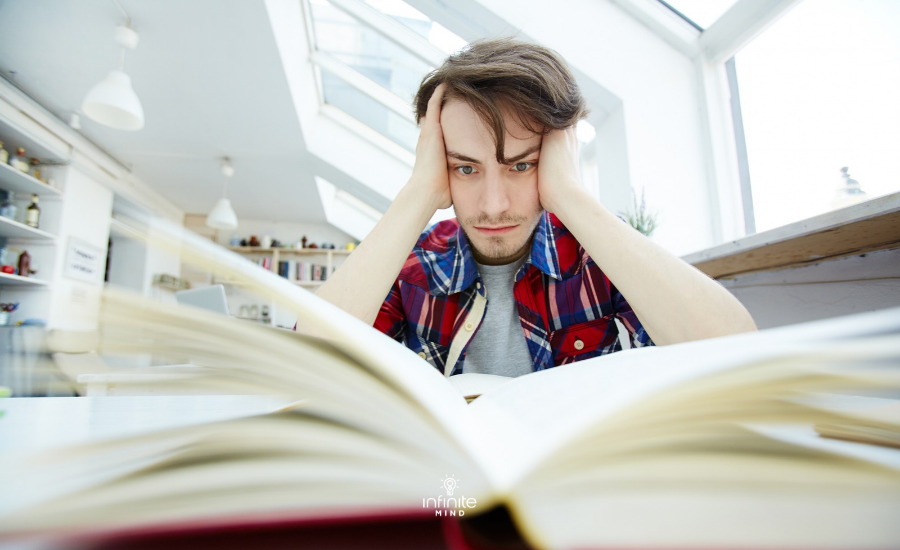 Stressed Man with Head in Hands Studying