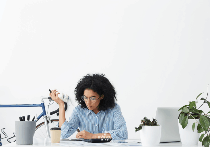 woman sitting at desk trying to focus on multiple tasks